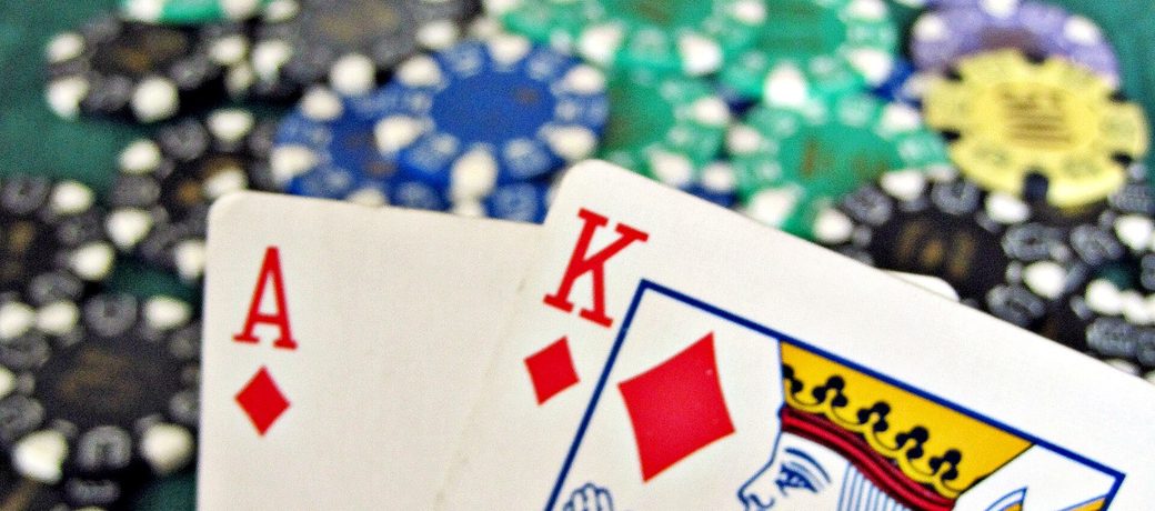 Blackjack-h&aring;nd med kort og jetoner p&aring; bordet